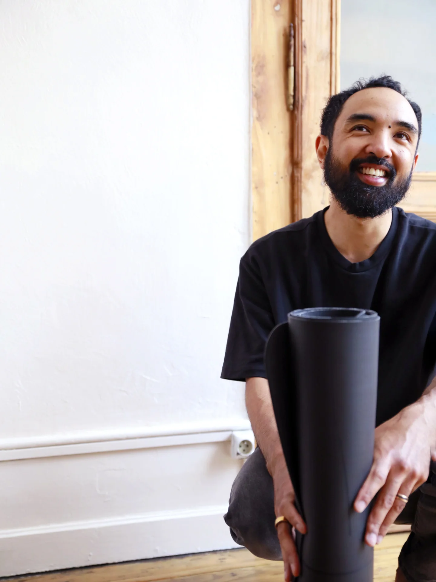 Yreh, professeur de yoga à Lille, tenant un tapis roulé